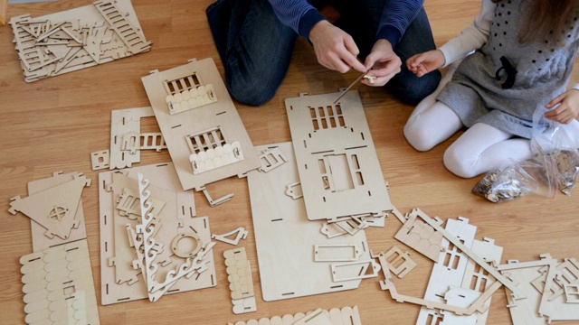 小女孩和爸爸一起建造木制玩具屋视频下载