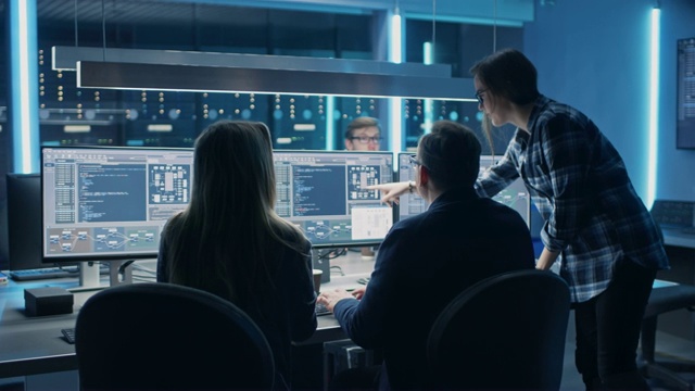 男、女IT工程师程序员在配备服务器机架的系统控制室台式机上编码。显示软件开发代码编写过程视频素材