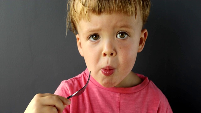 可爱的小男孩用叉子吃东西视频素材