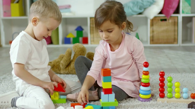 孩子们用五颜六色的塑料积木制作玩具塔视频下载