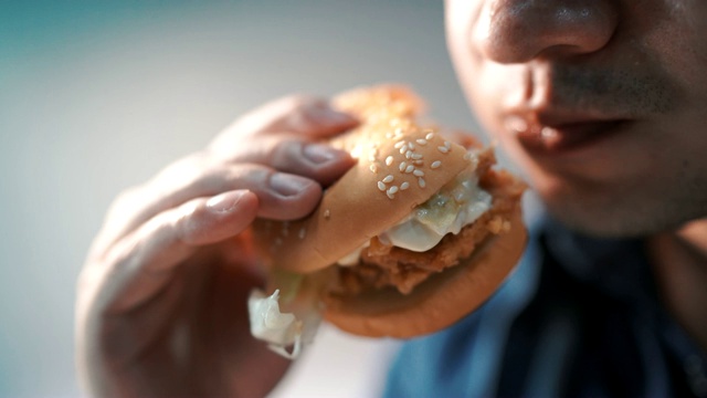 特写镜头里的人正在吃汉堡包。幸福的视频下载