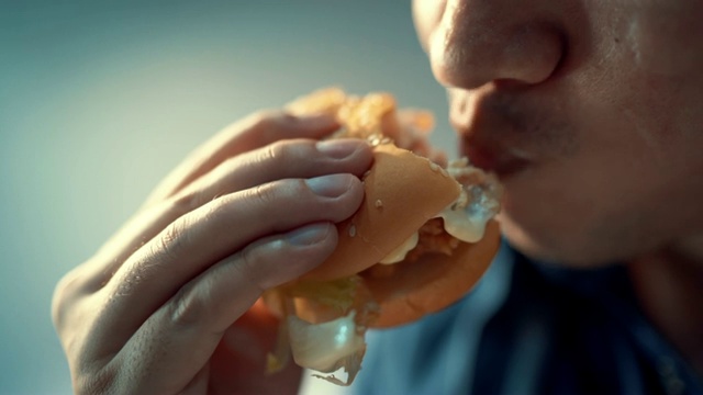 特写镜头里的人正在吃汉堡包。幸福的视频素材
