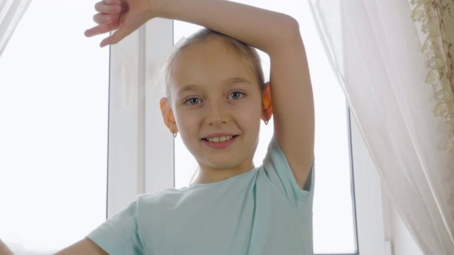 欢快的少女有乐趣和跳舞前摄像头在窗口背景。视频素材