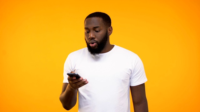 年轻的非裔美国人拿着手机，发着工作批准信息，申请视频素材