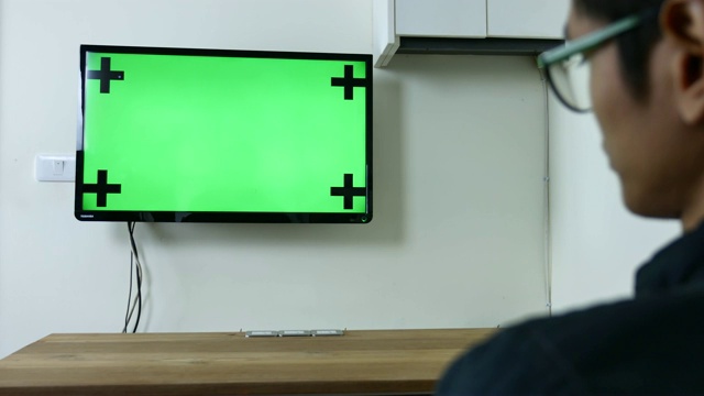 男子观看绿色模拟屏幕电视视频素材