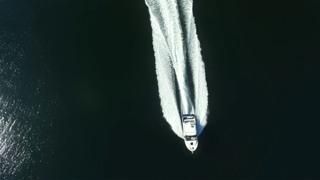 天线:白色摩托艇在阳光下穿过黑暗的湖视频下载
