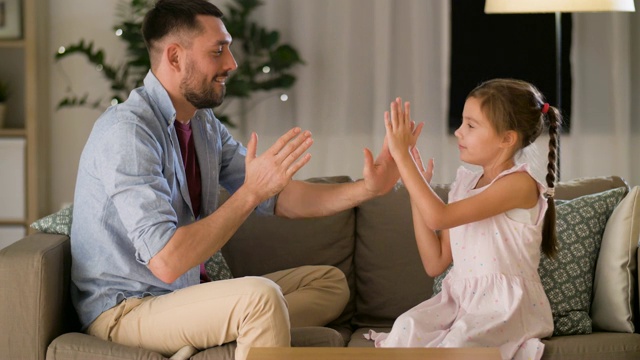 快乐的爸爸和女儿在家里玩拍手游戏视频下载