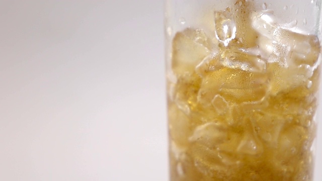 将可乐和冰块倒入玻璃杯中，靠近视频素材