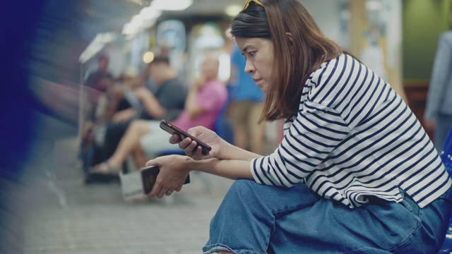 一名亚洲女性在机场使用智能手机视频素材