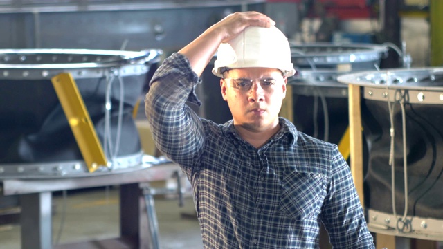 西班牙人在金属制造厂工作，戴安全帽视频素材