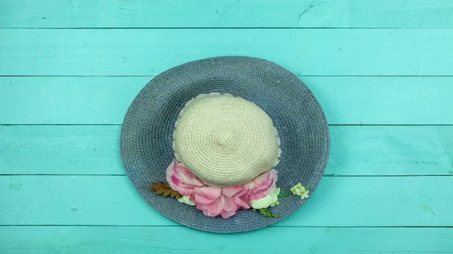 停止运动动画的女士海滩帽子在蓝色木制的背景视频下载