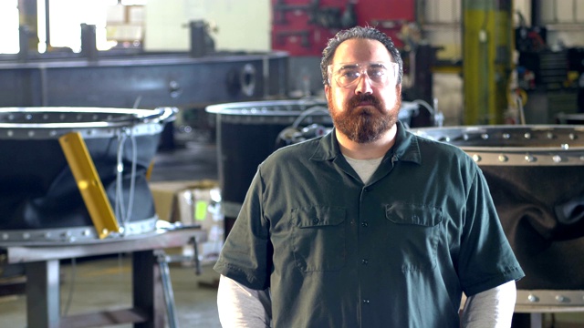有胡子的男子在金属加工厂工作视频素材
