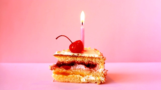 生日蛋糕与樱桃和燃烧的蜡烛为生日在粉红色的背景视频素材