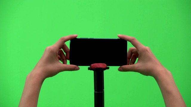 女人的手一直在绿色背景上使用手机视频素材