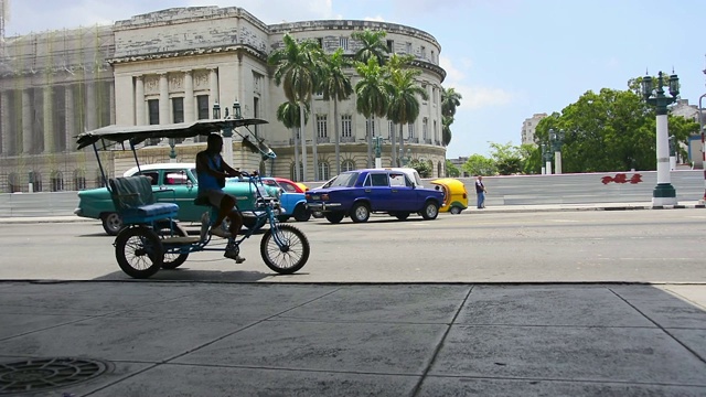 哈瓦那，古巴，建立拍摄的“卡皮托里奥”地区与老爷车行驶视频下载