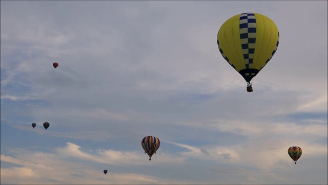 黄昏时分，五颜六色的热气球在天空中平静地漂浮着视频素材