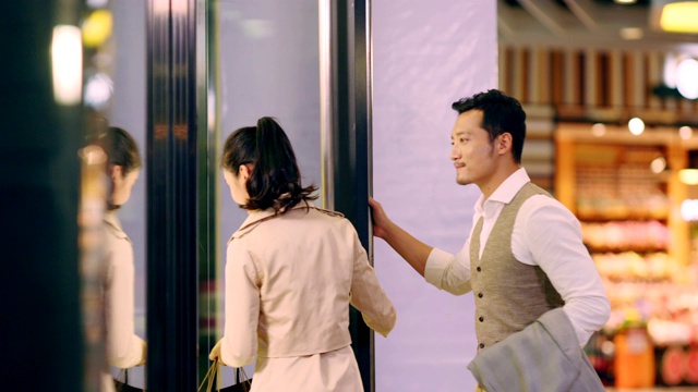 一对亚洲夫妇走进购物中心的一家商店视频素材