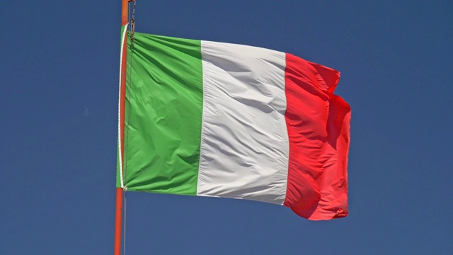 慢动作特写镜头的意大利国旗在风中飘扬。背景是蓝色的天空视频素材