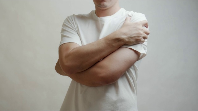 一名穿着白衬衫的亚洲男子在他的肩膀上感到疼痛。肌肉疼痛，保健理念。视频下载