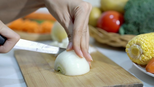 在砧板上切洋葱，为烹饪做准备。视频素材