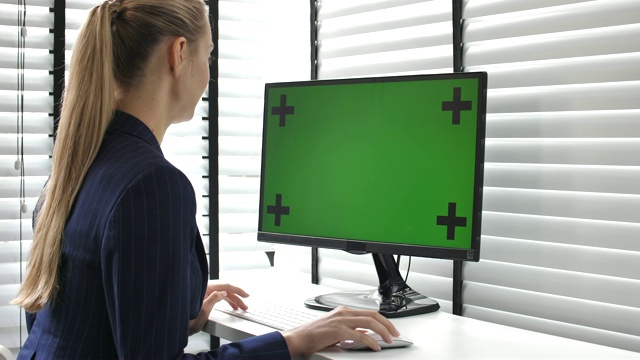 女商人在她的办公室里使用绿色屏幕的电脑视频素材