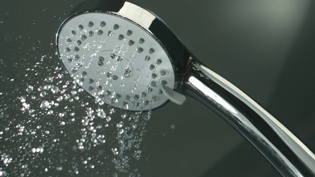 淋浴喷头，水从浴室的水龙头喷溅而出，以慢动作流动视频素材