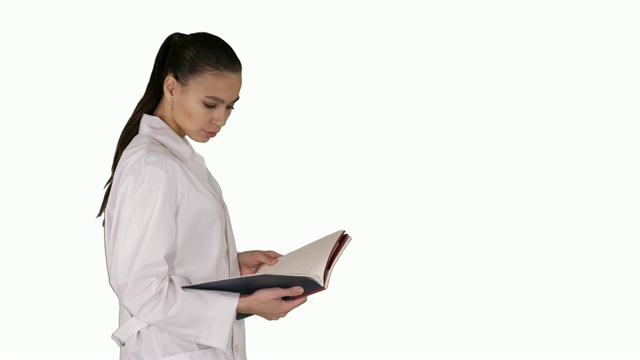迷人的医学学生或医生与笔记本行走和阅读在白色的背景视频下载