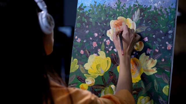 戴着耳机的女画家描绘大自然视频素材