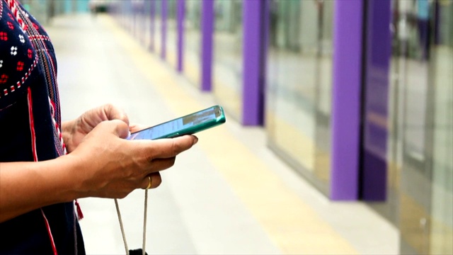 一名女性在地铁站使用智能手机视频素材