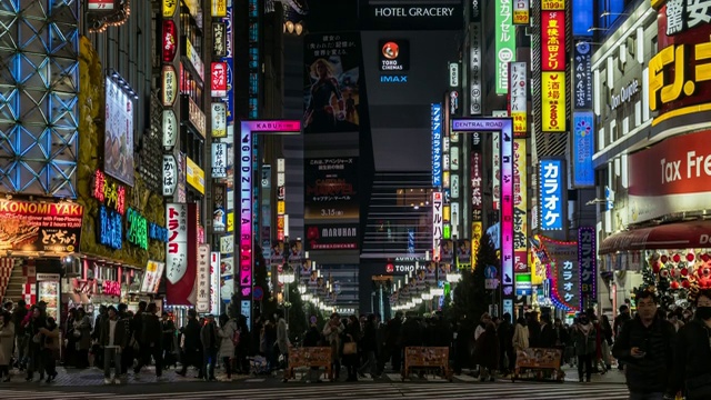 4K时间的推移，新宿在晚上，人群不明的人走在人行道上，汽车在东京，日本。日本霓虹街文化与购物概念视频素材