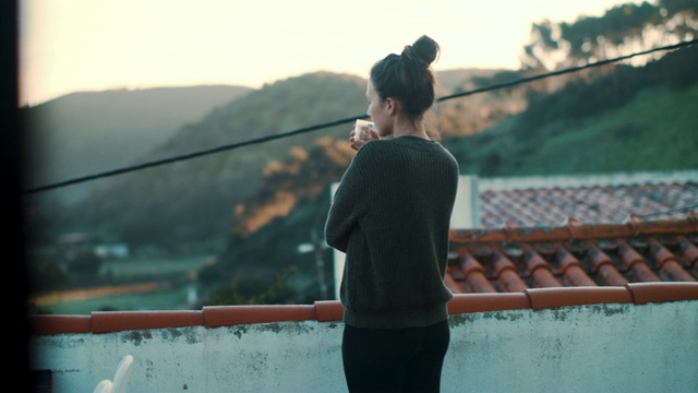 早晨，葡萄牙妇女在屋顶露台上喝水视频素材
