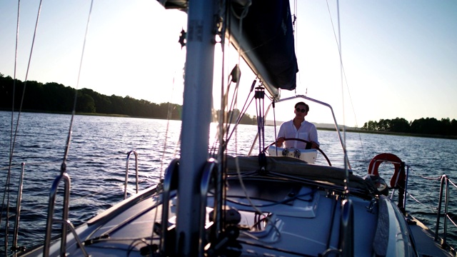 宁静的湖上日落。年轻人喜欢航海视频下载