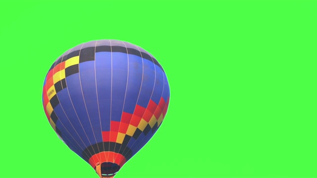 4K视频跟踪拍摄蓝色彩色热气球在空中飞行在壮观的白色天空和绿色屏幕或色度键背景。视频素材