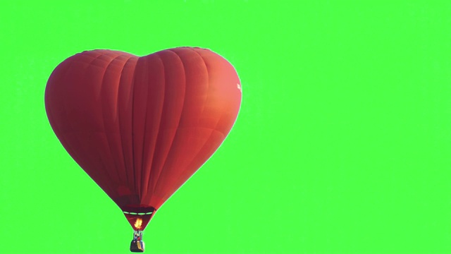 4K视频跟踪拍摄红色单心形状热气球在空中飞行，在壮观的白色天空和绿色屏幕或色度键背景。视频素材