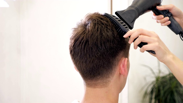 理发师用吹风机做发型。完成美容。理发店里的吹风机男视频素材