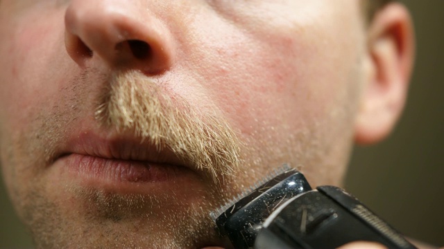 男人剃胡子与电动修剪近距离视频素材