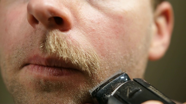 男人剃胡子与电动修剪近距离视频素材
