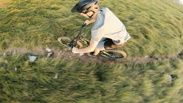 在山上的草地上骑山地自行车视频素材
