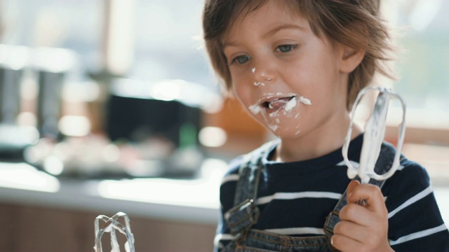 可爱的孩子品尝打蛋器的奶油视频下载