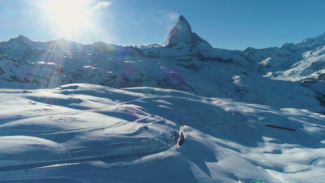 马特洪山和火车在阳光明媚的冬日。瑞士阿尔卑斯山。瑞士。鸟瞰图。揭示拍摄视频素材