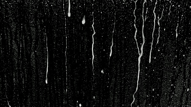 雨滴落在黑色的背景上。背景可以删除使用混合模式，如添加。视频素材