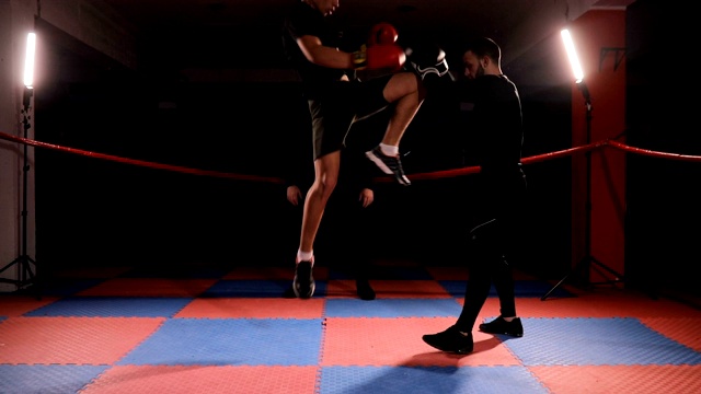 教练看着踢拳手在拳击场上节省训练视频下载