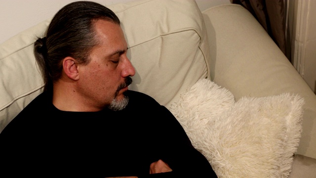 一个男人睡在家里的沙发上视频素材