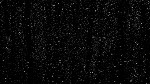 雨滴落在黑色的背景上。背景可以删除使用混合模式，如添加。视频素材