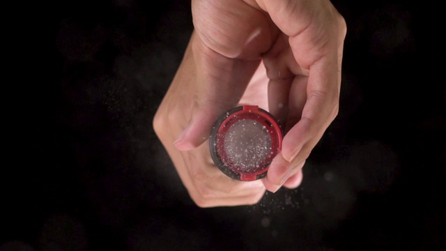慢镜头:用盐磨粉机在镜头上方撒盐。视频素材