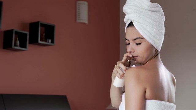 一名西班牙裔年轻女子洗澡后在身上涂抹保湿霜视频下载