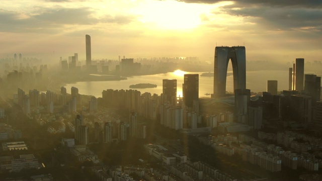 鸟瞰图城市与升起的太阳之间的摩天大楼视频素材