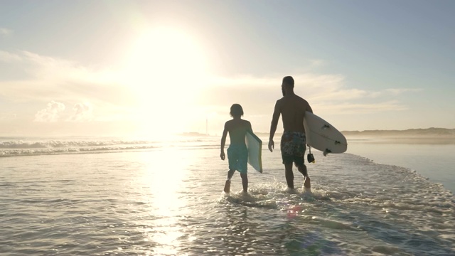 父子俩带着冲浪板走进了大海视频下载