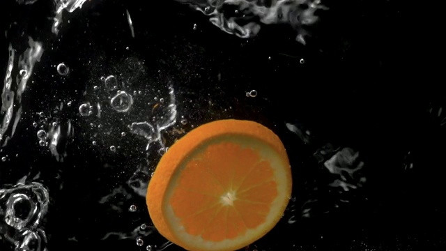 橙滴入水中溅起水花的慢动作。视频素材