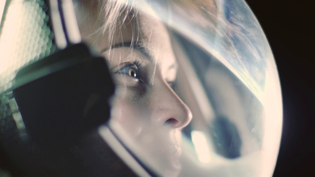 肖像拍摄的勇敢的女宇航员戴着头盔在太空中，环顾四周的奇迹。太空旅行，探索和太阳系殖民概念。视频素材